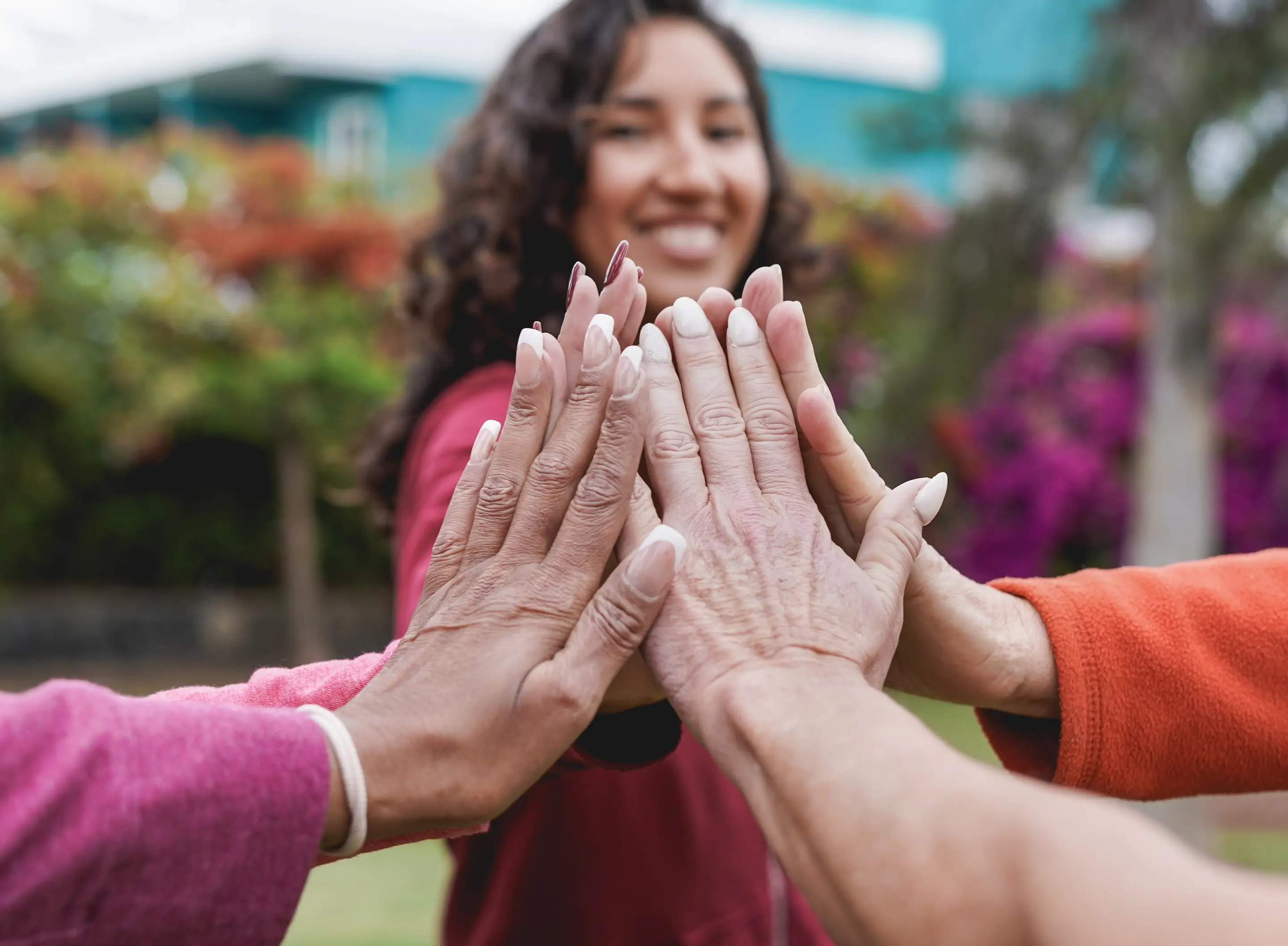 Multiracial women stacking hands in unity and community support